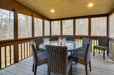 a screened in porch with a table and chairs at Hot Tub, Game Room! Poconos Home 22 Mi to Slopes in Gouldsboro