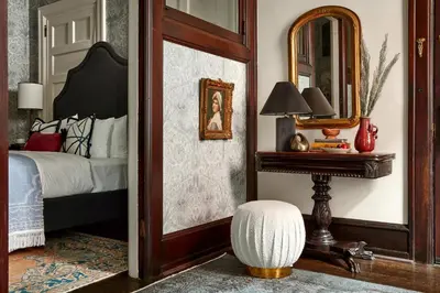 a bedroom with a bed and a mirror and a table at Guild House Hotel in Philadelphia