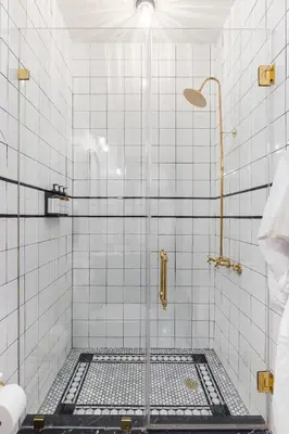a bathroom with a shower with white tiles at Guild House Hotel in Philadelphia