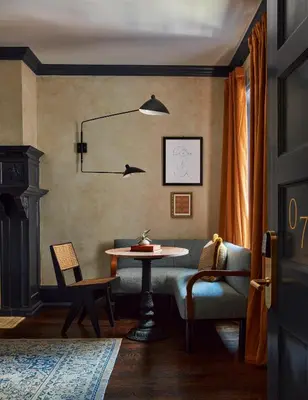 a dining room with a table and chairs and a lamp at Guild House Hotel in Philadelphia