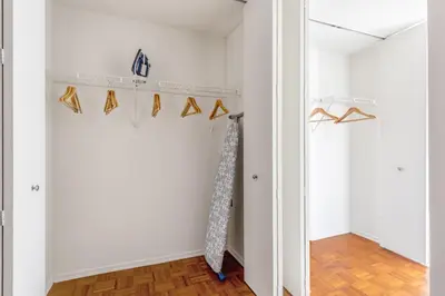 a room with white walls and wooden floors and a shelf with shoes at Chelsea 1BR w Gym Concierge nr Penn Stn MSG NYC-439 in New York