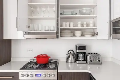 a kitchen with white cabinets and a stove top oven at Chelsea 1BR w Gym Concierge nr Penn Stn MSG NYC-439 in New York