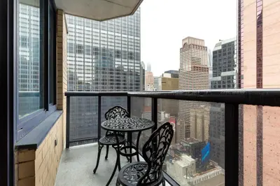 a balcony with two chairs and a table on a balcony at 1BR nr Times Sq w Indoor pool Doorman NYC-50 in New York