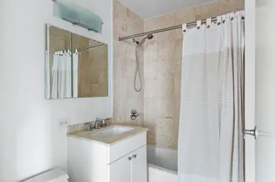 a white bathroom with a sink and a shower at 1BR nr Times Sq w Indoor pool Doorman NYC-50 in New York