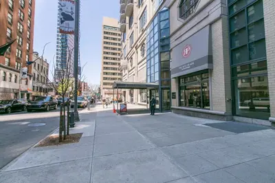 a city street with buildings and a person walking on the sidewalk at 1BR nr Times Sq w Indoor pool Doorman NYC-50 in New York