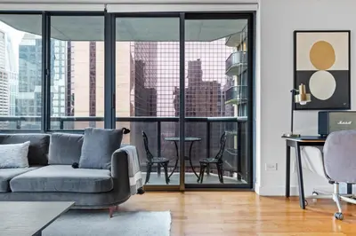 a living room with a couch and a large window at 1BR nr Times Sq w Indoor pool Doorman NYC-50 in New York