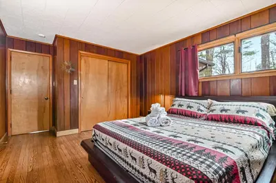 a bedroom with a bed with a teddy bear on it at Woodland Cabin Retreat in Lake Harmony