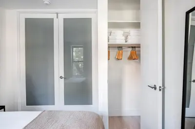 a bedroom with white walls and a closet with glass doors at East Village 1br w wd nr Union Sq NYC-936 in New York