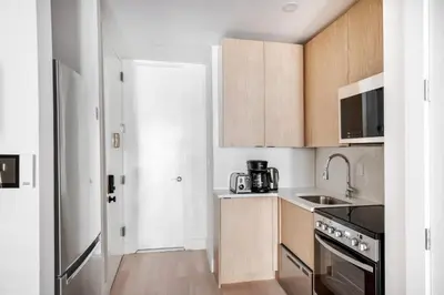 a small kitchen with wooden cabinets and a sink at East Village 1br w wd nr Union Sq NYC-936 in New York