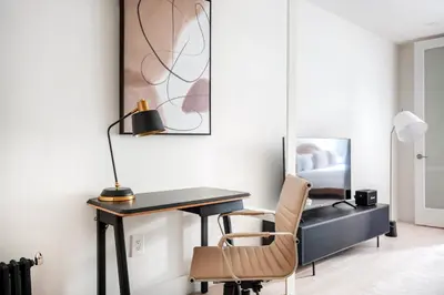 a desk with a lamp and a chair in a room at East Village 1br w wd nr Union Sq NYC-936 in New York