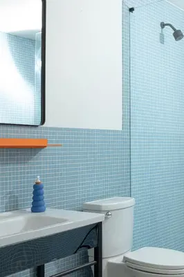 a bathroom with a toilet and a sink and a mirror at YOWIE Hotel in Philadelphia