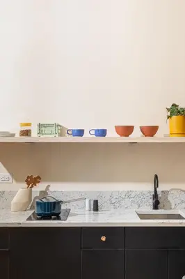 a kitchen with a sink and shelves with bowls at YOWIE Hotel in Philadelphia