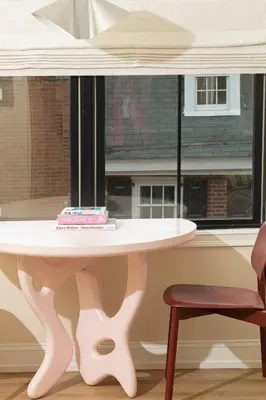 a table in front of a window with a cake on it at YOWIE Hotel in Philadelphia