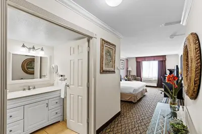 a bathroom with a sink and a bed in a room at Executive Inn - Fort Lee in Fort Lee