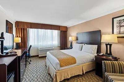 a hotel room with a bed and a desk and a television at Executive Inn - Fort Lee in Fort Lee