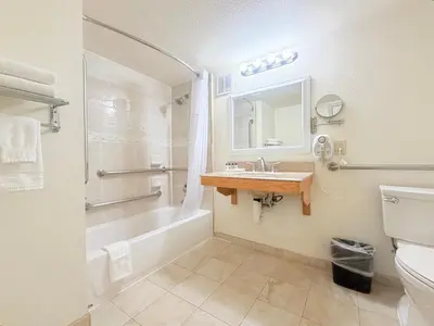 a bathroom with a tub and a sink and a toilet at Executive Inn - Fort Lee in Fort Lee