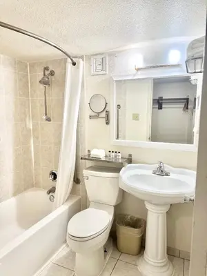 a bathroom with a white toilet and a sink at Executive Inn - Fort Lee in Fort Lee
