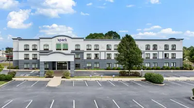 a large white building with a parking lot at Spark by Hilton Lancaster Dutch Country in Lancaster