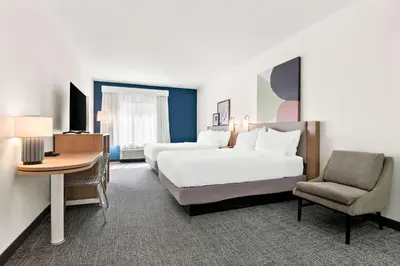 a hotel room with two beds and a desk and a chair at Spark by Hilton Lancaster Dutch Country in Lancaster