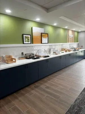 a lobby with a long counter with blue cabinets at Spark by Hilton Lancaster Dutch Country in Lancaster