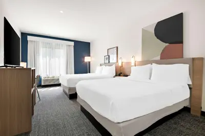 a hotel room with two beds and a television at Spark by Hilton Lancaster Dutch Country in Lancaster