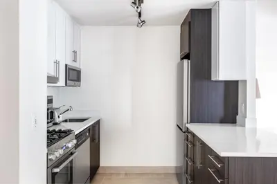 a kitchen with white cabinets and a sink and a stove at Chelsea 1BR w Gym Concierge nr Penn Station NYC-438 in New York