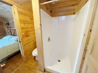a small bathroom with a shower and a toilet at Deluxe Cabin Within Campground in Mifflinburg
