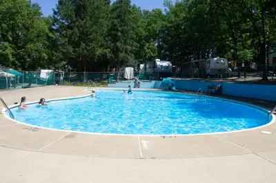 a group of people playing in a swimming pool at Deluxe Cabin Within Campground in Mifflinburg