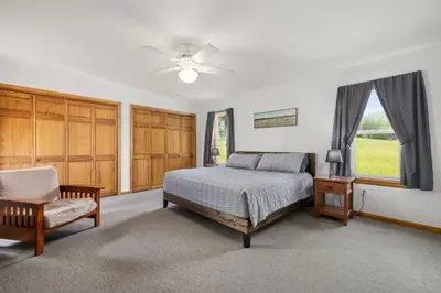 a bedroom with a bed and a chair and a window at Entire House within Campground in Mifflinburg