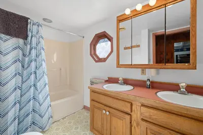 a bathroom with two sinks and a mirror and a tub at Entire House within Campground in Mifflinburg