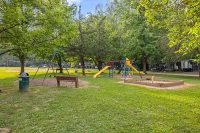 a park with playground equipment in the grass at Entire House within Campground in Mifflinburg