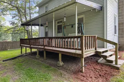 a large wooden porch on a house at Entire House within Campground in Mifflinburg