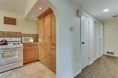 a kitchen with wooden cabinets and a white stove at Milford Family Home with Koi Pond and Porch! in West Milford