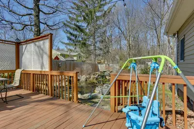 a playground on a wooden deck with a swing at Milford Family Home with Koi Pond and Porch! in West Milford