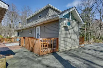 a small house with a wooden gate in a driveway at Milford Family Home with Koi Pond and Porch! in West Milford