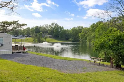 a park with a bench next to a lake at Cozy Cabin2 Within Campground in Mifflinburg