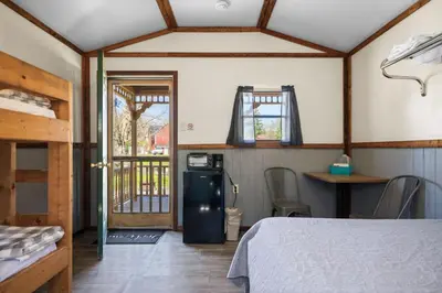 a room with a bed and a refrigerator in a room at Cozy Cabin2 Within Campground in Mifflinburg