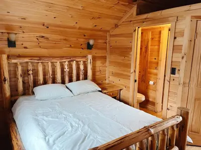 a bedroom with a bed in a log cabin at Deluxe Cabin6 Within Campground in Mifflinburg