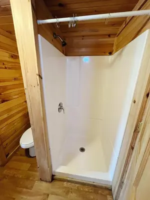 a bathroom with a shower and a toilet at Deluxe Cabin6 Within Campground in Mifflinburg