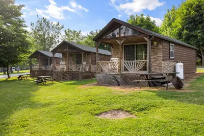 a log cabin with a picnic table in a yard at Deluxe Cabin6 Within Campground in Mifflinburg