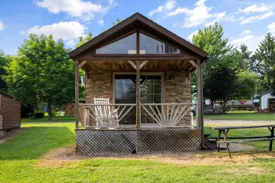 a small cabin with a table in a park at Deluxe Cabin6 Within Campground in Mifflinburg