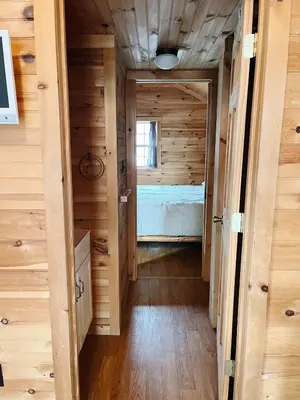 a hallway leading to a bedroom in a tiny house at Deluxe Cabin7 Within Campground in Mifflinburg