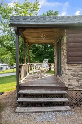 a wooden porch with rocking chairs on a house at Deluxe Cabin7 Within Campground in Mifflinburg