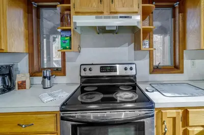 a kitchen with a stove top oven in a kitchen at Lovely Poconos Cabin with Resort Amenities! in Gouldsboro
