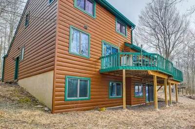 a large wooden house with a balcony on it at Lovely Poconos Cabin with Resort Amenities! in Gouldsboro