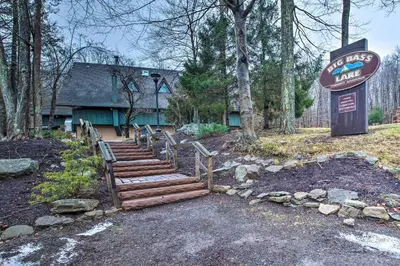 a house with a sign and stairs in front of it at Lovely Poconos Cabin with Resort Amenities! in Gouldsboro