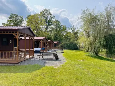 a group of lodges in a park with a picnic table at Cozy Cabin3 Within Campground in Mifflinburg