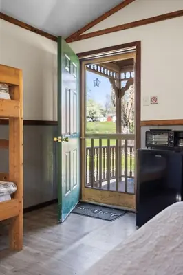 a room with a door open to a balcony at Cozy Cabin3 Within Campground in Mifflinburg