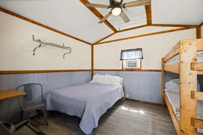 a bedroom with a bed and a ceiling fan at Cozy Cabin3 Within Campground in Mifflinburg