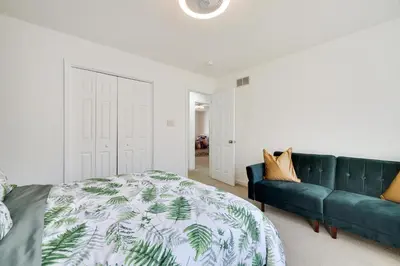 a bedroom with a green bed and a couch at Stunning Poconos Villa- Hot Tub, Pool, Game Room, BBQ & more in East Stroudsburg